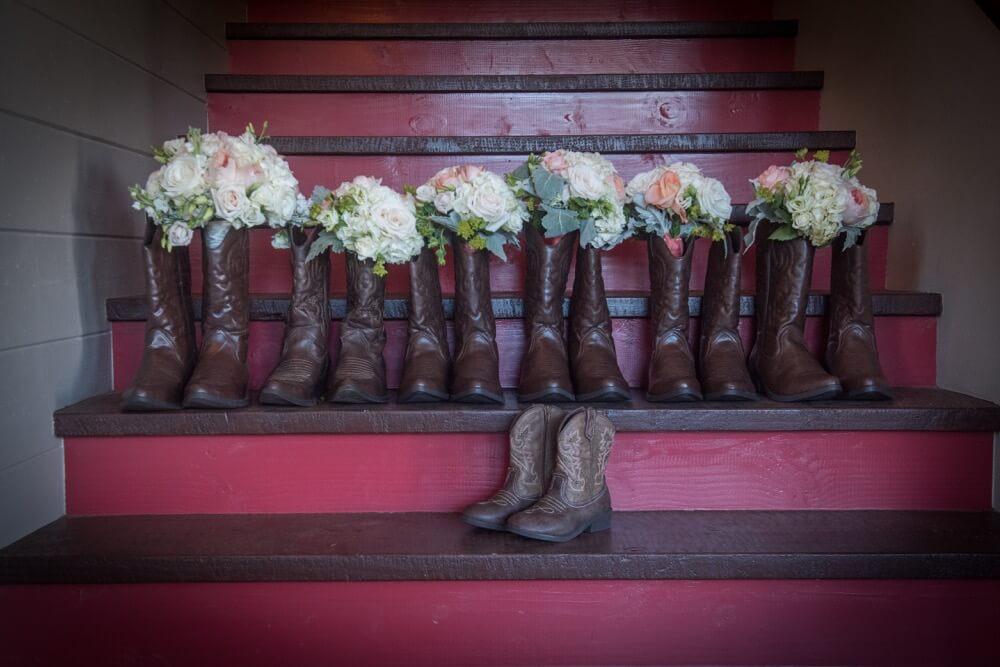 Cowboy boots on stairs filled with bridal bouquets